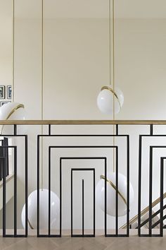 a room with white walls, black and gold accents and wooden flooring that has an abstract design on the wall