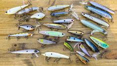 many different types of fishing lures on a wooden surface