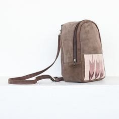 The lightweight mini backpack lets you carry your essentials in comfort and minimalist style with a low profile. Sophistication meets function in this lovely little backpack which perfectly fits your wallet, phone and even your favorite book. Traditional techniques and natural dyes are used to achieve these gorgeous hues of sand, pink and purple. Main compartment: 8" x 10" x 3" Front pocket: 7" x 4.5" Internal zippered pocket Straps: 31" - 35" Everyday Backpack With Mobile Phone Bag, Beige Crossbody Backpack For Everyday Use, Beige Travel Backpack With Mobile Phone Bag, Beige Backpack With Cell Phone Pocket For Everyday Use, Beige Backpack With Phone Pocket For Daily Use, Beige Leather Backpack With Zipper Pocket, Beige Travel Backpack With Cell Phone Pocket, Wool Tote, Hooked Pillow