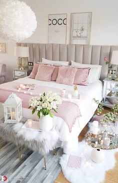 a bedroom decorated in pink and white with candles on the nightstands, bedding and pillows