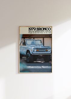 an old brochure is hanging on the wall above a car parked in front of it