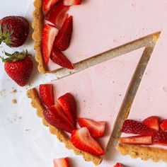 a strawberry tart is cut into slices and placed on a plate with strawberries