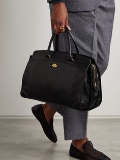 Métier's 'Private Eye' tote might just be named for its subtlety, however the attention to detail doesn't go unnoticed. Made from leather in a generous size, it features the signature diamond-shaped twist-lock at the front and gold-tone feet to protect the base. The strategically placed external and internal pockets ensure your phone, keys and even documents are organized and accessible. Elegant Black Briefcase With Dust Bag, Luxury Double Handle Briefcase For Work, Elegant Bags With Leather Handles For Business Trips, Luxury Briefcase With Leather Handles For Work, Elegant Black Briefcase With Gold-tone Hardware, Elegant Briefcase With Leather Lining For Travel, Elegant Top Handle Briefcase For Business Trips, Luxury Tote Briefcase For Business Trips, Luxury Briefcase For Business Trips