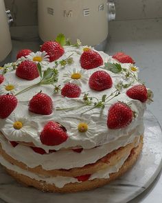 a cake with white frosting and strawberries on top