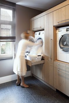 a woman in a white dress is doing something on the washer and dryer