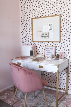 a pink chair sitting in front of a white desk