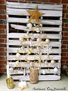 a christmas tree made out of pallet wood with ornaments and lights on the top