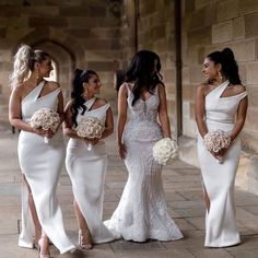 the bridesmaids are all dressed up in white gowns and holding bouquets