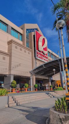 the entrance to a shopping center with palm trees