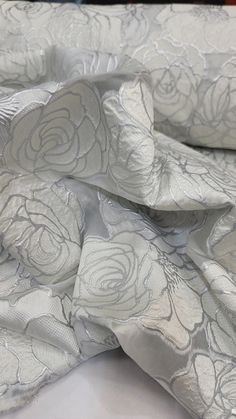 the fabric is white and has flowers on it, as if they were made out of satin