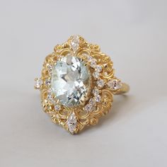 a ring with an aqua blue stone surrounded by white and clear stones on a plain surface