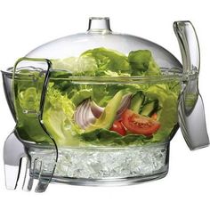 a glass bowl filled with lettuce, tomatoes and onion on top of ice