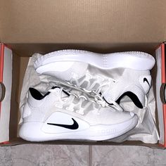 a pair of white nike sneakers in a box