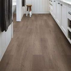 a kitchen with white cabinets and wood flooring