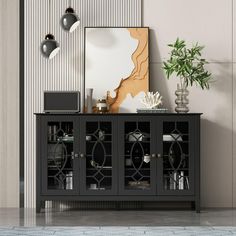 a black sideboard with glass doors in a living room next to a potted plant