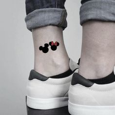 a pair of feet with mickey and minnie mouse tattoos on them