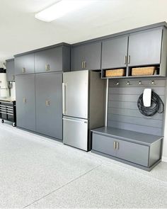 an organized garage with gray cabinets and drawers