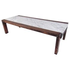 a marble top coffee table with wooden legs