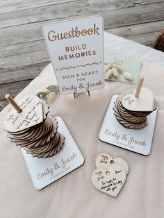 wedding guest book and memory tags on a bed with wooden heart - shaped magnets