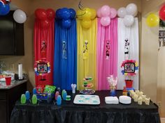 a party table with balloons, cake and candy