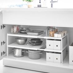 an open cabinet with pots and pans on it