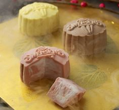 three different types of soaps on a yellow tray with red and pink decorations around them