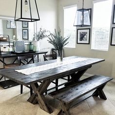 a dining room table with benches and pictures on the wall