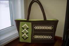 a brown and green bag sitting on top of a wooden floor next to a window