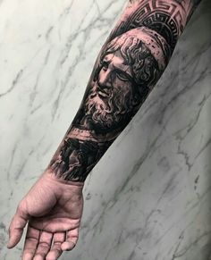 a man's arm with a black and grey tattoo on it