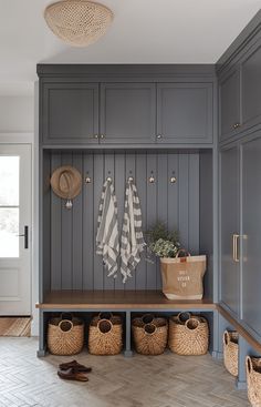 a mud room with gray cabinets and baskets