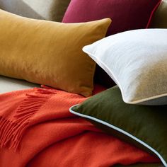 pillows and blankets are stacked on top of each other in the same color palettes