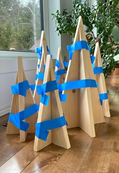 three wooden christmas trees with blue tape on them