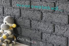 a stuffed monkey sitting on the side of a brick wall next to a sign that says craft passion