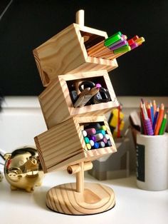 a wooden toy that is on top of a desk with pens and pencils in it