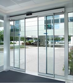 an empty room with sliding glass doors leading to the parking lot in front of it