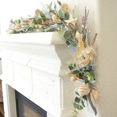 a fireplace mantel decorated with flowers and seashells