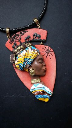 Oh! I am mad. The necklace is made of polymer clay. For your attention, the beauty from Africa. The sophisticated face, clothing and scarf is made by the style of polymer clay mosaic plus painting with acrylic. The necklace made in bright colors. On the background of the sunrise depicted a shadow of tree and an elephant family.
Elephants are a sacred symbol in Hindu and Buddhist religions, representing loyalty, power, wisdom, and fertility. Elephants are associated with water and rainfalls, and the shape, size, and color of their bodies are said to be symbols of clouds. Artistic Handmade Polymer Clay Necklace, Artistic Polymer Clay Pendant Necklaces, Artistic Polymer Clay Pendant Necklace, I Am Mad, Women Sculpture, Clay Mosaic, Womens Group, Polymer Clay Ornaments, Art Necklace