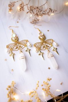 Soluna Quartz and butterfly earrings Welcome to the captivating realm of esoteric jewelry where each creation is imbued with mystery and meaning. With "Soluna", immerse yourself in a unique sensory experience where the golden radiance mixes with the magic of butterflies and the crystalline purity of natural quartz. The Magic of Butterflies: Imagine yourself floating in an enchanted garden, surrounded by butterflies with sparkling reflections. The butterfly, symbol of transformation and renewal, invites you to embrace change with grace and lightness. Each golden straw represents this inner metamorphosis, where each moment is an opportunity to reinvent oneself and flourish. The Purity of Natural Quartz: Suspended from these loops is a prism of natural quartz, a treasure of the Earth. Quartz, Butterfly Symbol, Esoteric Jewelry, Jewelry Butterfly, Quartz Jewelry, Enchanted Garden, Inner Beauty, Butterfly Earrings, The Butterfly, Jewelry Earrings Dangle