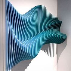 a blue sculpture is hanging on the wall