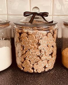 some cookies are in glass jars on the counter