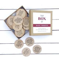 the tiny box of date nights is next to it's cardboard box and six small wooden discs