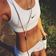 a woman in white sports bra and headphones