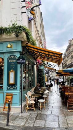 an outdoor cafe with tables and chairs on the sidewalk