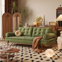 a living room with a green couch and coffee table in front of a large window