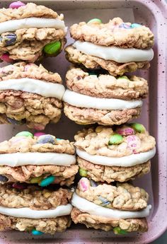 cookies with white frosting and sprinkles in a pink container