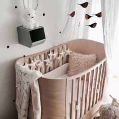 a baby crib in the corner of a room next to a window with birds on it