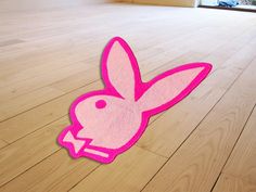 a pink rabbit rug sitting on top of a wooden floor