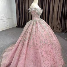 a pink ball gown on display in front of curtains