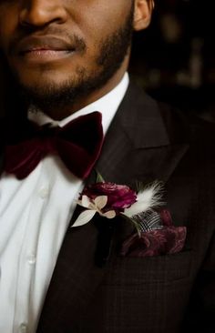 a close up of a person wearing a suit with a flower in his lapel