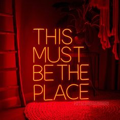 a neon sign that says, this must be the place